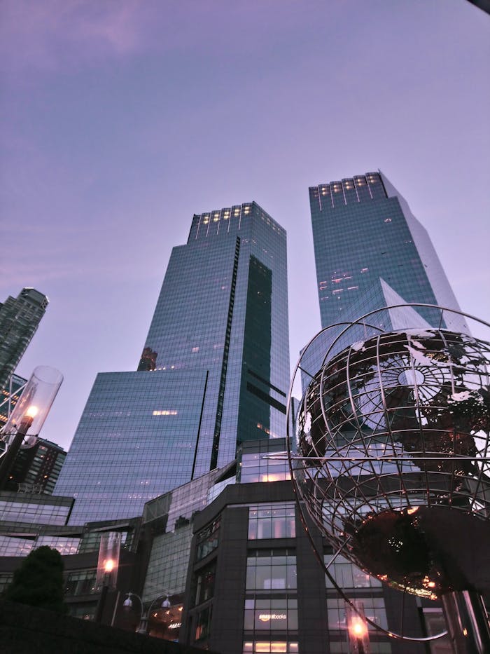 View of skyscrapers and globe sculpture at dusk in an urban cityscape, creating a modern architectural ambiance.